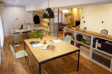Cette photo montre un bureau industriel avec un mur blanc, un sol en bois brun, un bureau indépendant et un sol marron.