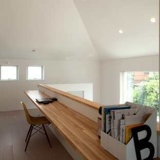 Idéer för mellanstora funkis hobbyrum, med vita väggar, plywoodgolv, ett inbyggt skrivbord och beiget golv