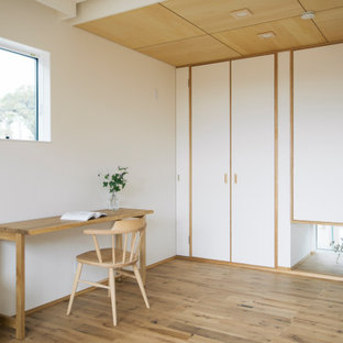 Inspiration för mellanstora asiatiska hemmabibliotek, med vita väggar, ett fristående skrivbord, beiget golv och mellanmörkt trägolv