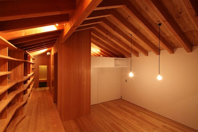 Modelo de despacho escandinavo sin chimenea con paredes blancas, suelo de madera en tonos medios y escritorio empotrado