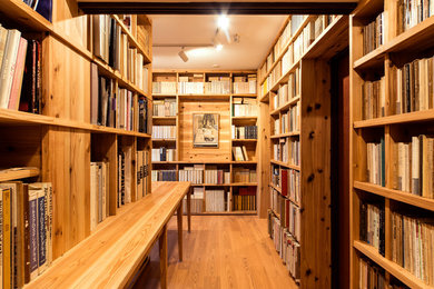 他の地域にある中くらいな北欧スタイルのおしゃれなホームオフィス・書斎 (ライブラリー、ベージュの壁、淡色無垢フローリング、造り付け机、ベージュの床) の写真