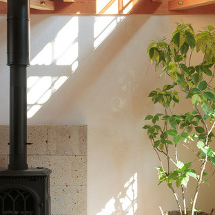 Modelo de estudio campestre con paredes blancas, escritorio independiente, estufa de leña y marco de chimenea de piedra