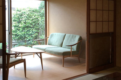 Ejemplo de despacho asiático pequeño con paredes verdes, suelo de madera clara y suelo marrón