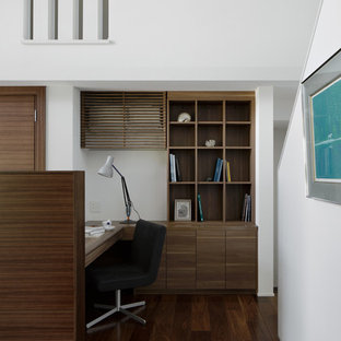 Immagine di un ufficio contemporaneo di medie dimensioni con pareti bianche, parquet scuro, stufa a legna, cornice del camino piastrellata, scrivania incassata e pavimento marrone