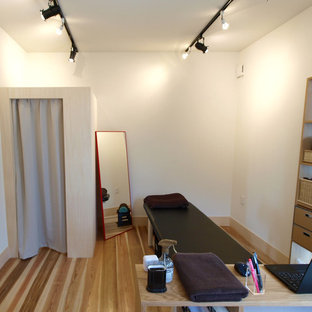Foto di una sala pesi scandinava con pareti bianche, parquet chiaro e pavimento beige