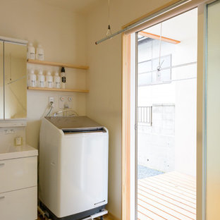 Aménagement d'une buanderie scandinave en L multi-usage et de taille moyenne avec un évier intégré, un mur blanc et un sol en bois brun.