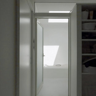 Exempel på en modern tvättstuga enbart för tvätt och med garderob, med vita väggar och ljust trägolv