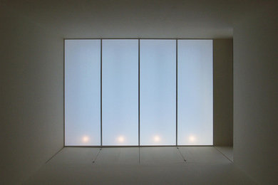 Cette image montre un salon minimaliste ouvert avec un mur blanc, une cheminée standard, un sol en bois brun et un manteau de cheminée en bois.
