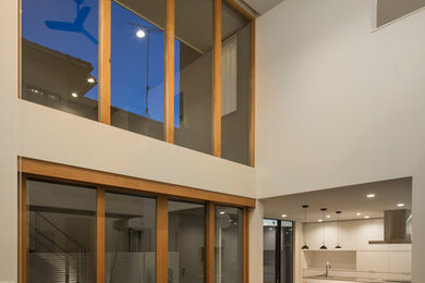 Immagine di un soggiorno moderno aperto con pareti bianche, parquet scuro, TV a parete e pavimento marrone