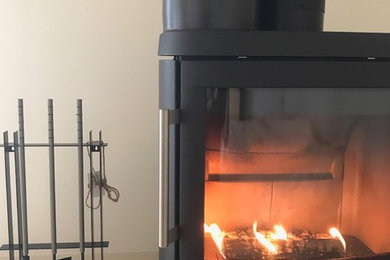 オーフスにある北欧スタイルのおしゃれなリビング (タイルの暖炉まわり) の写真