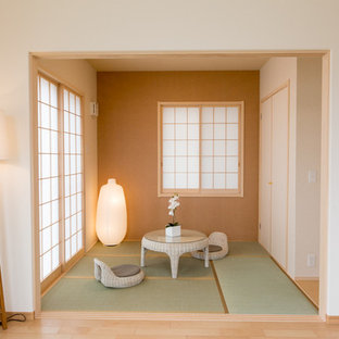 Kleines, Repräsentatives, Fernseherloses, Abgetrenntes Asiatisches Wohnzimmer ohne Kamin mit oranger Wandfarbe und Tatami-Boden in Tokio
