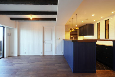 Modelo de salón contemporáneo con paredes blancas, suelo de madera oscura, suelo marrón, vigas vistas y boiserie