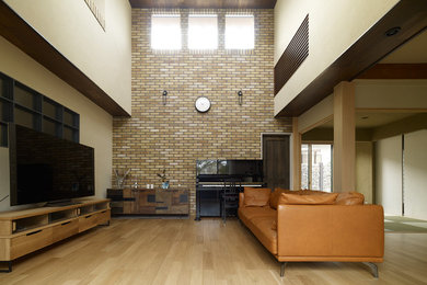 Ejemplo de salón asiático con paredes blancas, suelo de madera clara, televisor independiente y suelo beige