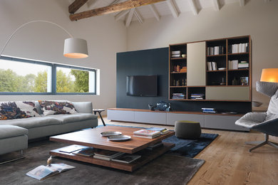 Landhaus Wohnzimmer mit TV-Wand, weißer Wandfarbe, braunem Holzboden und braunem Boden in Sonstige