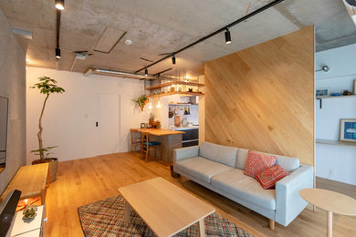 Uriges Wohnzimmer mit weißer Wandfarbe, hellem Holzboden, TV-Wand und beigem Boden in Tokio