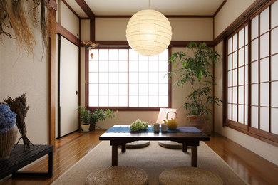 Modelo de salón asiático de tamaño medio sin chimenea con paredes beige, suelo de madera en tonos medios y suelo marrón