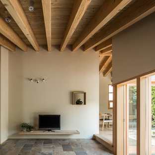 Immagine di un soggiorno etnico con pareti beige, nessun camino, TV autoportante e pavimento con piastrelle in ceramica