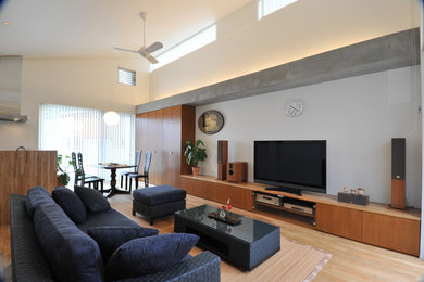Свежая идея для дизайна: большая открытая гостиная комната в современном стиле с белыми стенами, паркетным полом среднего тона, отдельно стоящим телевизором и коричневым полом - отличное фото интерьера