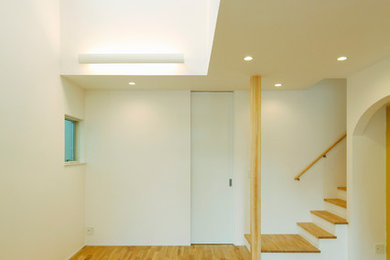 Ejemplo de salón minimalista de tamaño medio con paredes blancas, suelo de madera clara y suelo marrón