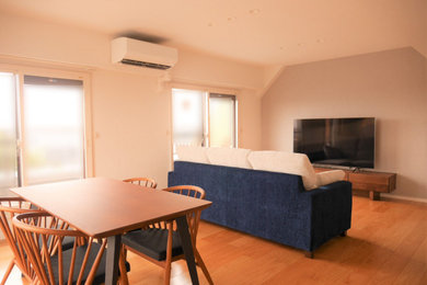 Imagen de salón abierto de tamaño medio sin chimenea con paredes blancas, suelo de contrachapado, suelo marrón, papel pintado y papel pintado