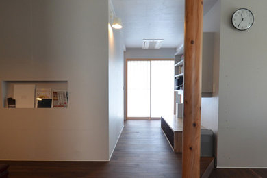 Immagine di un soggiorno moderno aperto con pareti grigie, pavimento in compensato, TV autoportante e pavimento nero