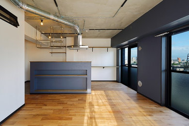 Modelo de salón abierto urbano de tamaño medio sin chimenea con paredes multicolor, suelo de madera en tonos medios y suelo marrón