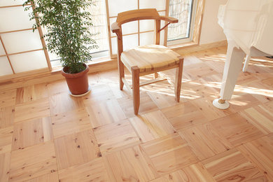 Modelo de salón para visitas grande con paredes blancas y suelo de madera clara
