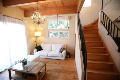 Idée de décoration pour un salon avec un mur blanc, un sol en bois brun et un sol marron.