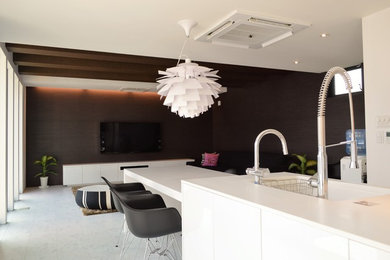 На фото: открытая гостиная комната в стиле модернизм с коричневыми стенами, полом из фанеры и телевизором на стене без камина с