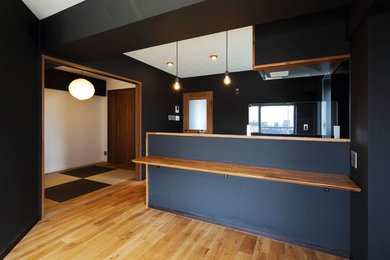 Mittelgroßes, Offenes Modernes Wohnzimmer ohne Kamin mit schwarzer Wandfarbe, braunem Holzboden und braunem Boden in Tokio