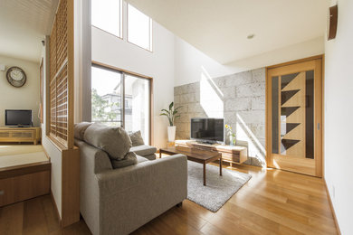 Diseño de salón abierto de estilo zen con paredes blancas, suelo de madera en tonos medios, televisor independiente y suelo marrón