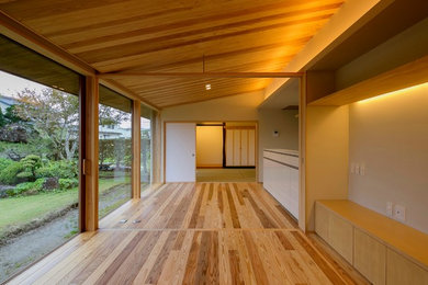 Modelo de salón abierto asiático con suelo de madera en tonos medios