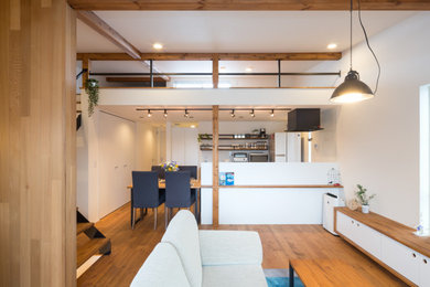Immagine di un soggiorno aperto con pavimento in legno massello medio e travi a vista
