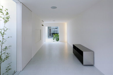 Ejemplo de salón blanco minimalista pequeño con paredes blancas, suelo de linóleo, televisor colgado en la pared y suelo gris