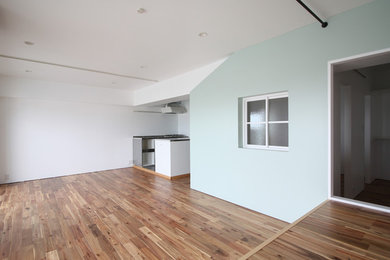 Offenes Modernes Wohnzimmer mit weißer Wandfarbe, braunem Holzboden und braunem Boden in Osaka