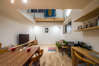 Ejemplo de salón abierto moderno de tamaño medio con paredes blancas, suelo de madera clara, televisor independiente y suelo beige