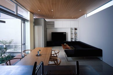 Imagen de salón abierto minimalista sin chimenea con paredes blancas, suelo blanco y televisor independiente