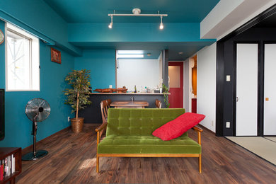 Inspiration för små asiatiska loftrum, med blå väggar, mörkt trägolv, en fristående TV och brunt golv