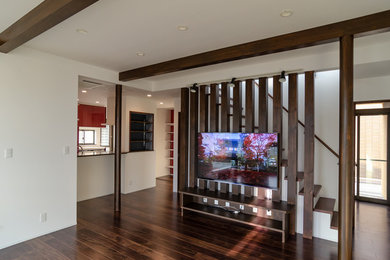 Immagine di un soggiorno moderno di medie dimensioni e aperto con pareti bianche, pavimento in compensato, TV a parete e pavimento marrone