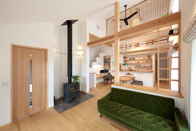Foto de salón abierto nórdico con paredes blancas, suelo de madera clara y suelo marrón