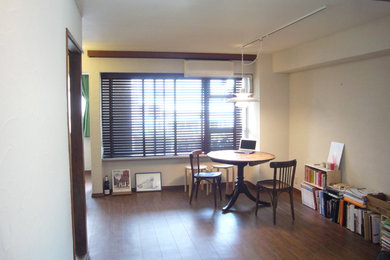 Foto di un soggiorno industriale aperto con libreria, pareti bianche, TV autoportante e pavimento marrone