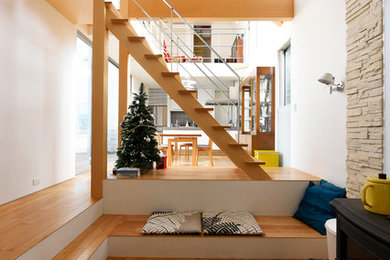 Idee per un soggiorno contemporaneo aperto con pareti bianche, pavimento in legno massello medio, stufa a legna e nessuna TV