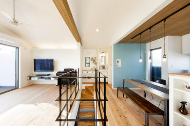 Ejemplo de salón abierto minimalista de tamaño medio sin chimenea con paredes blancas, suelo de madera en tonos medios, televisor colgado en la pared y suelo marrón