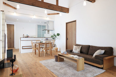 Foto de salón abierto de tamaño medio sin chimenea con paredes blancas, suelo de madera oscura, televisor independiente y suelo marrón
