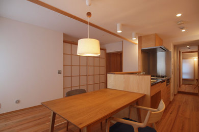 Diseño de salón abierto escandinavo con paredes blancas, suelo de madera en tonos medios y suelo marrón