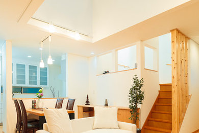 Imagen de salón abierto rústico con paredes blancas, suelo de madera en tonos medios y suelo marrón