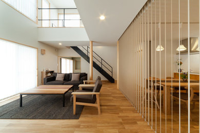 Imagen de salón de estilo zen de tamaño medio sin chimenea y televisor con paredes blancas y suelo de madera en tonos medios