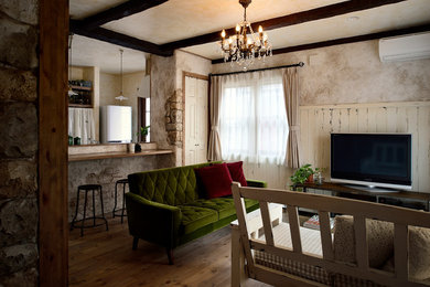 Offenes Klassisches Wohnzimmer mit bunten Wänden, braunem Holzboden, freistehendem TV und braunem Boden in Sonstige
