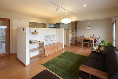 Imagen de salón minimalista con paredes blancas, televisor independiente, suelo beige y suelo de madera en tonos medios