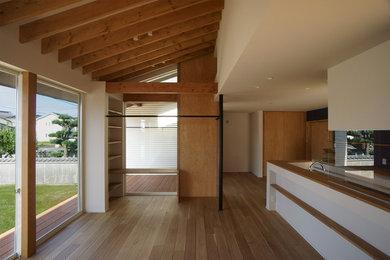Modelo de salón abierto moderno con paredes blancas y suelo de madera en tonos medios